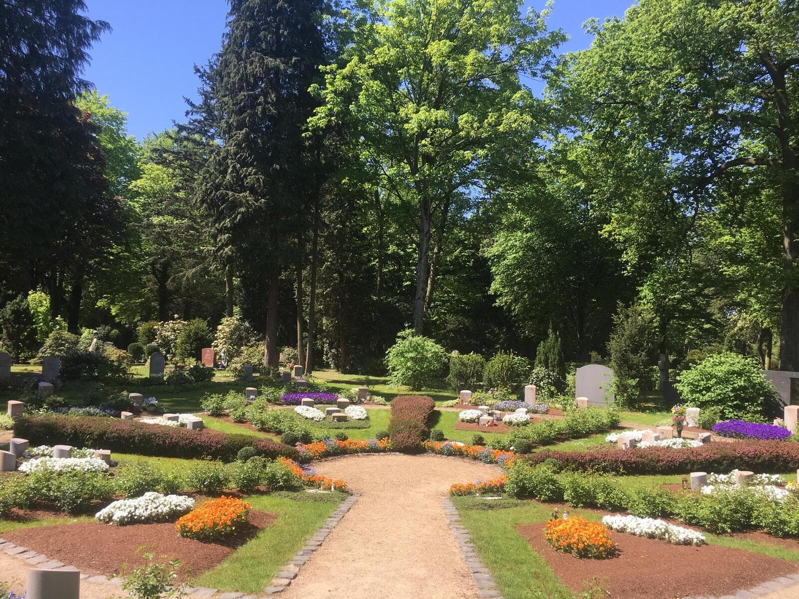 Blick in den Rosengarten auf dem Siegburger Nordfriedhof mit rund angelegten, bepflanzten Beeten