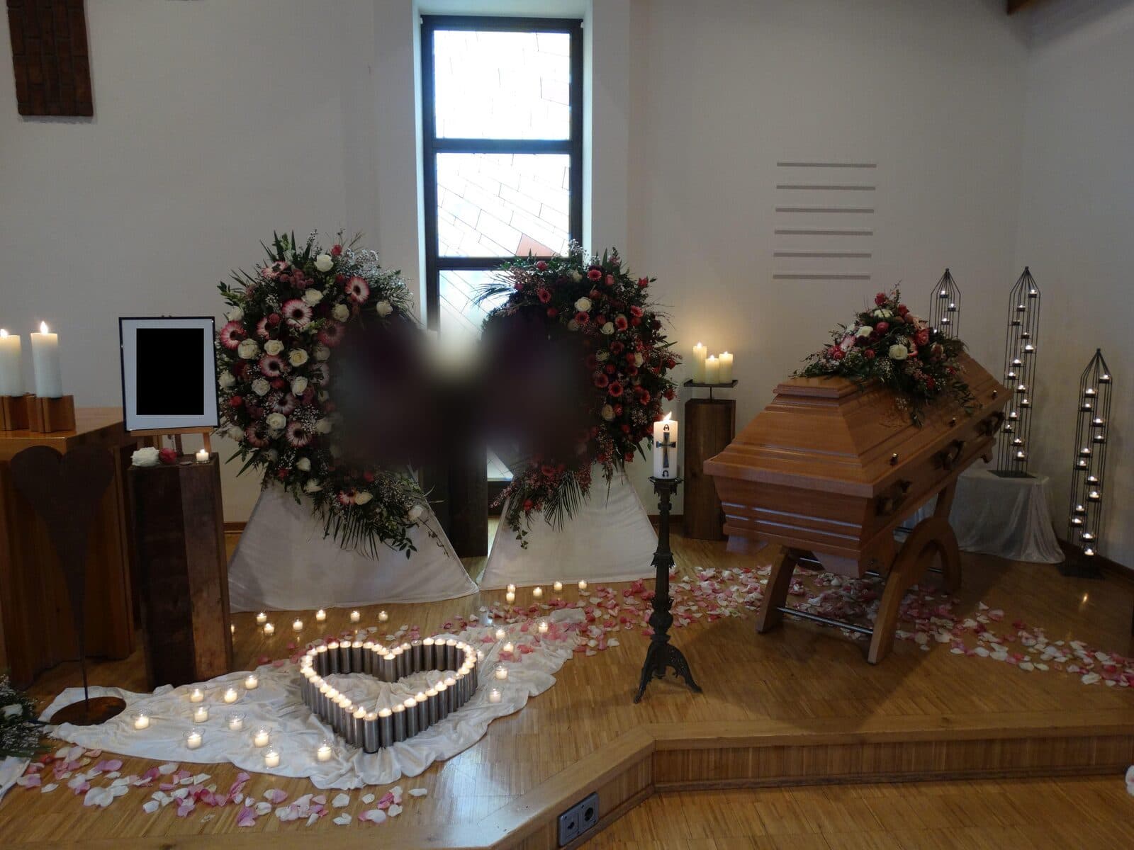 Aufgebahrter Sarg mit Blumenschmuck in einer Kirche